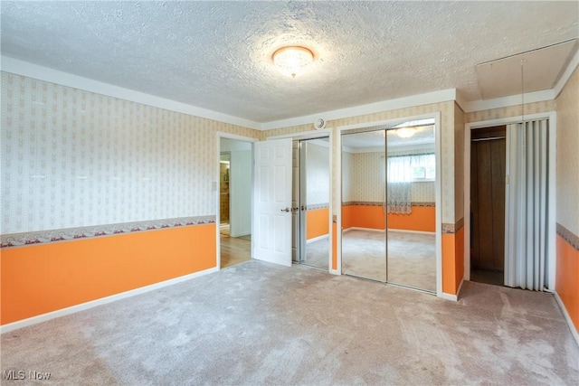 4944 Coleman Dr, Akron, OH 44319 - unfurnished bedroom featuring wallpapered walls, carpet flooring, two closets, a textured ceiling, and attic access