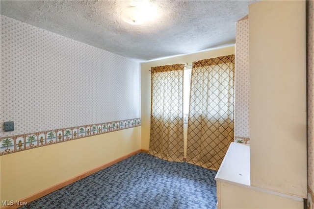 4944 Coleman Dr, Akron, OH 44319 - empty room with carpet floors, a textured ceiling, wallpapered walls, and baseboards
