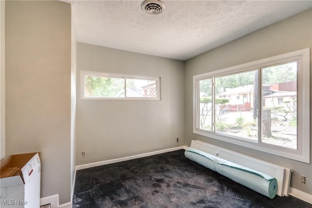 4944 Coleman Dr, Akron, OH 44319 - unfurnished room with a baseboard heating unit, a textured ceiling, baseboards, and dark colored carpet