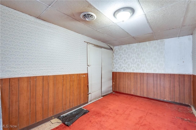 4944 Coleman Dr, Akron, OH 44319 - basement featuring wallpapered walls, a drop ceiling, a wainscoted wall, and wooden walls