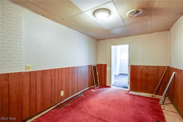 4944 Coleman Dr, Akron, OH 44319 - carpeted empty room featuring wainscoting, a drop ceiling, wallpapered walls, and wood walls