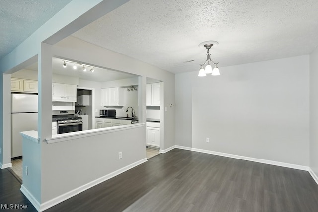 17682 Eastbrook Trl, Chagrin Falls, OH 44023 - kitchen featuring stainless steel gas stove, freestanding refrigerator, dark wood-type flooring, a sink, and a textured ceiling