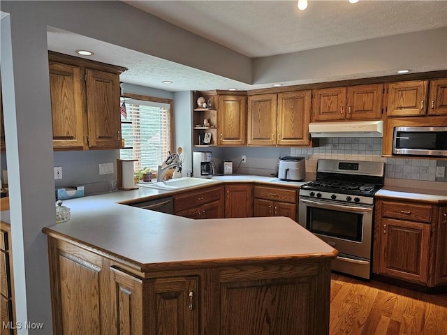 6671 Queens Way N, Royalton, OH 44133 - kitchen featuring appliances with stainless steel finishes, under cabinet range hood, open shelves, light countertops, and decorative backsplash