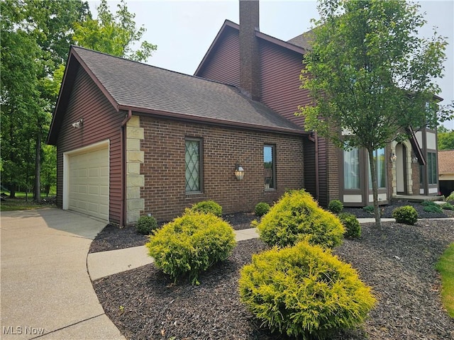 6671 Queens Way N, Royalton, OH 44133 - view of property exterior featuring a chimney, brick siding, driveway, an attached garage, and roof with shingles