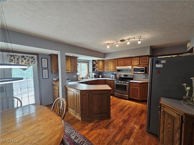 6671 Queens Way N, Royalton, OH 44133 - kitchen featuring appliances with stainless steel finishes, under cabinet range hood, wood finished floors, a sink, and a peninsula