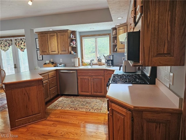 6671 Queens Way N, Royalton, OH 44133 - kitchen with open shelves, stainless steel appliances, a sink, a peninsula, and light wood-style flooring