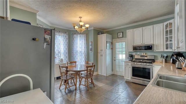 21 E Maple Ave, New Concord, OH 43762 - kitchen featuring appliances with stainless steel finishes, a chandelier, white cabinets, a textured ceiling, and glass insert cabinets