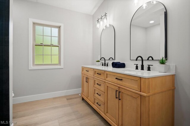 6730 Stone Rd, Medina, OH 44256 - bathroom featuring double vanity, wood finished floors, and baseboards