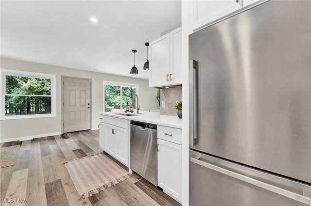 5679 Wilson Mills Rd, Highland Heights, OH 44143 - kitchen with appliances with stainless steel finishes, a sink, white cabinets, light countertops, and light wood-style flooring