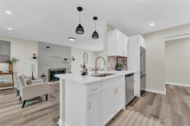 5679 Wilson Mills Rd, Highland Heights, OH 44143 - kitchen with a sink, appliances with stainless steel finishes, light wood-type flooring, open floor plan, and white cabinets
