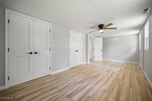 403 Palomino Ct, Lagrange, OH 44050 - unfurnished bedroom with light wood-style flooring, baseboards, multiple closets, a textured ceiling, and a ceiling fan