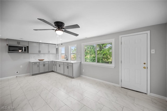 403 Palomino Ct, Lagrange, OH 44050 - kitchen with gray cabinetry, stainless steel microwave, a sink, light marble finish flooring, and baseboards