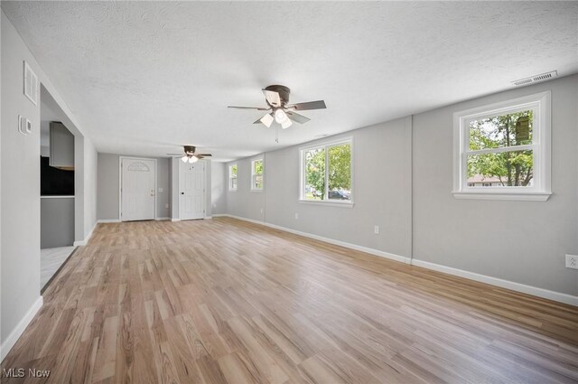 403 Palomino Ct, Lagrange, OH 44050 - unfurnished living room with ceiling fan, light wood finished floors, baseboards, and a textured ceiling