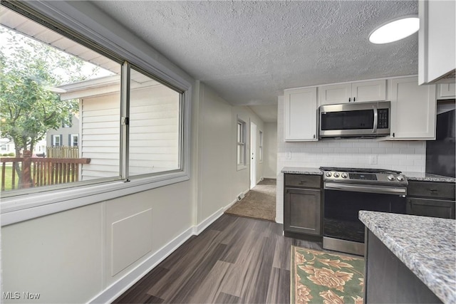 20969 Stanford, Fairview Park, OH 44126 - kitchen with appliances with stainless steel finishes, dark wood finished floors, decorative backsplash, light stone counters, and white cabinetry