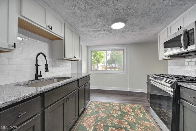20969 Stanford, Fairview Park, OH 44126 - kitchen featuring appliances with stainless steel finishes, a sink, dark wood finished floors, backsplash, and baseboards