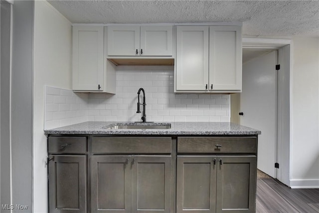 20969 Stanford, Fairview Park, OH 44126 - kitchen with a sink, dark wood-style flooring, decorative backsplash, light stone counters, and a textured ceiling