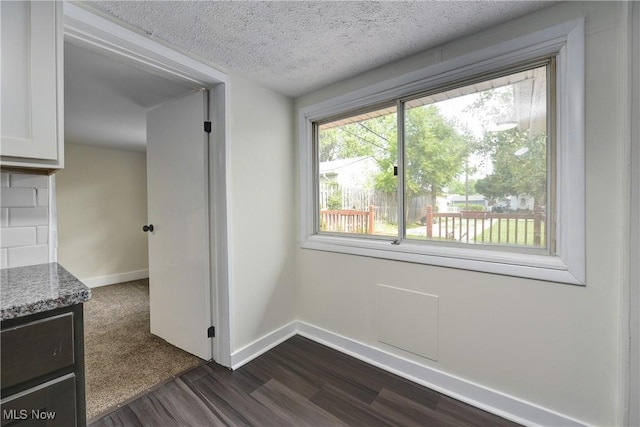 20969 Stanford, Fairview Park, OH 44126 - unfurnished dining area featuring dark wood-style flooring, baseboards, and a textured ceiling