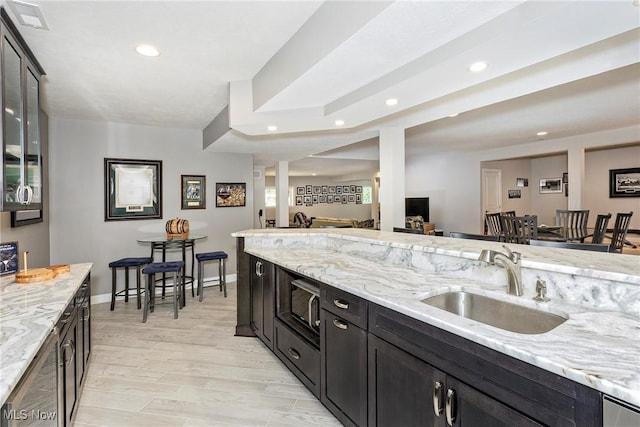 660 Shinnecock Ln, Aurora, OH 44202 - kitchen featuring a sink, recessed lighting, light stone counters, open floor plan, and baseboards