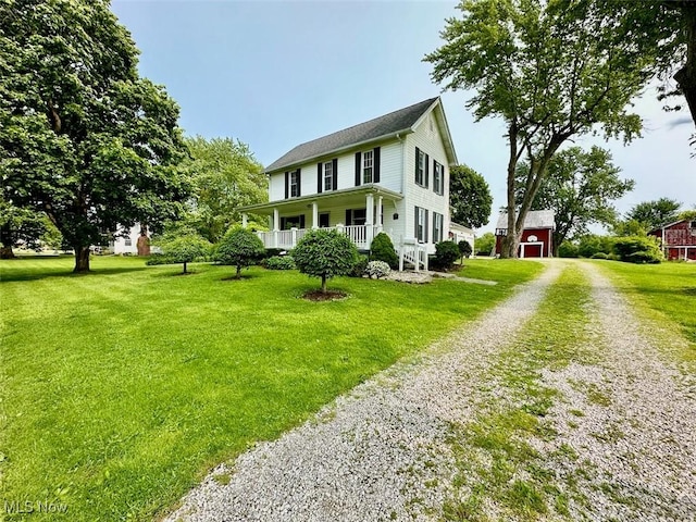 184 W Jefferson St, Jefferson, OH 44047 - view of front of house featuring driveway, a front yard, covered porch, and an outbuilding