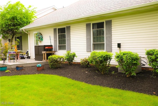 682 2nd St Unit 1, Fairport Harbor, OH 44077 - entrance to property featuring roof with shingles, a lawn, and a patio area