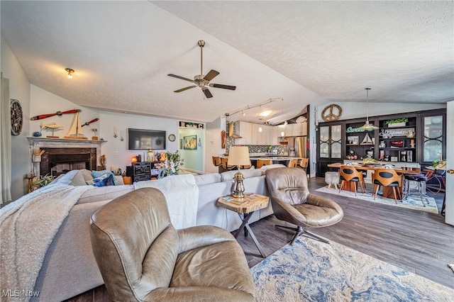 682 2nd St Unit 1, Fairport Harbor, OH 44077 - living area with lofted ceiling, wood finished floors, ceiling fan, a textured ceiling, and a fireplace