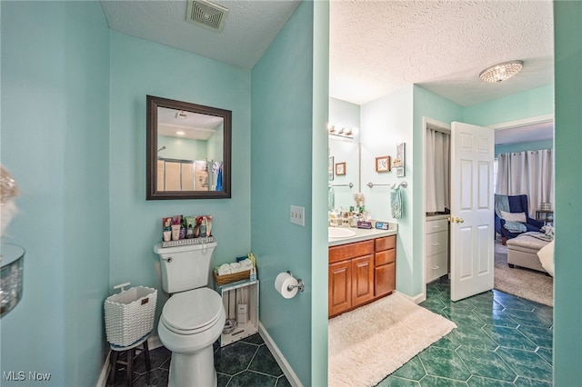 682 2nd St Unit 1, Fairport Harbor, OH 44077 - ensuite bathroom with vanity, toilet, tile patterned flooring, baseboards, and a textured ceiling