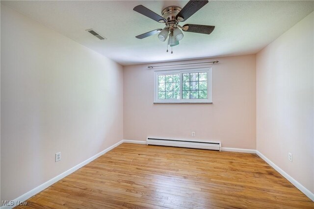 5046 Devon Dr, North Olmsted, OH 44070 - spare room featuring a baseboard heating unit, wood finished floors, baseboards, and a ceiling fan