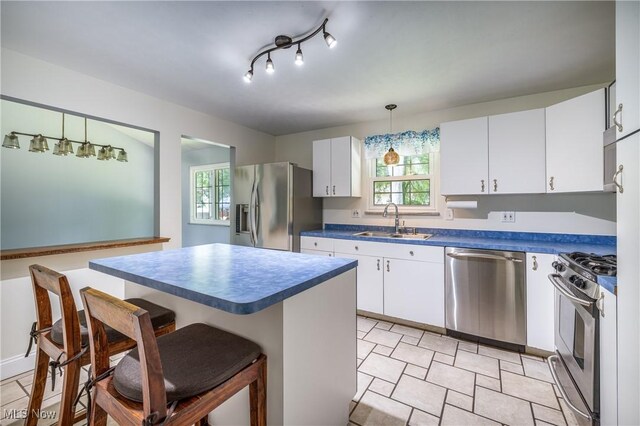 5046 Devon Dr, North Olmsted, OH 44070 - kitchen with appliances with stainless steel finishes, a sink, a breakfast bar area, white cabinets, and dark countertops