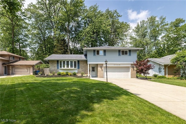 5046 Devon Dr, North Olmsted, OH 44070 - tri-level home with brick siding, a garage, concrete driveway, and a front lawn
