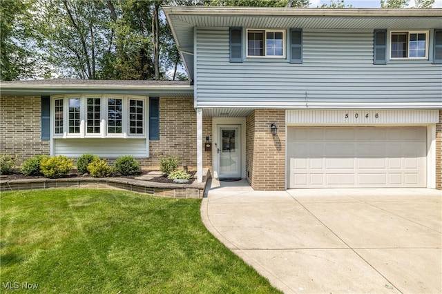 5046 Devon Dr, North Olmsted, OH 44070 - tri-level home featuring brick siding, an attached garage, and driveway