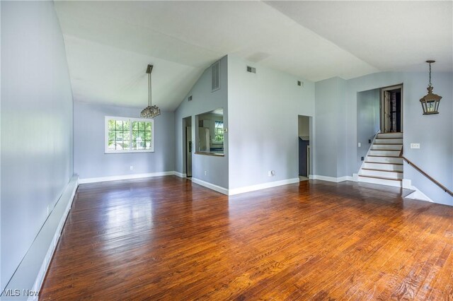 5046 Devon Dr, North Olmsted, OH 44070 - unfurnished living room with vaulted ceiling, wood finished floors, a chandelier, stairs, and baseboards