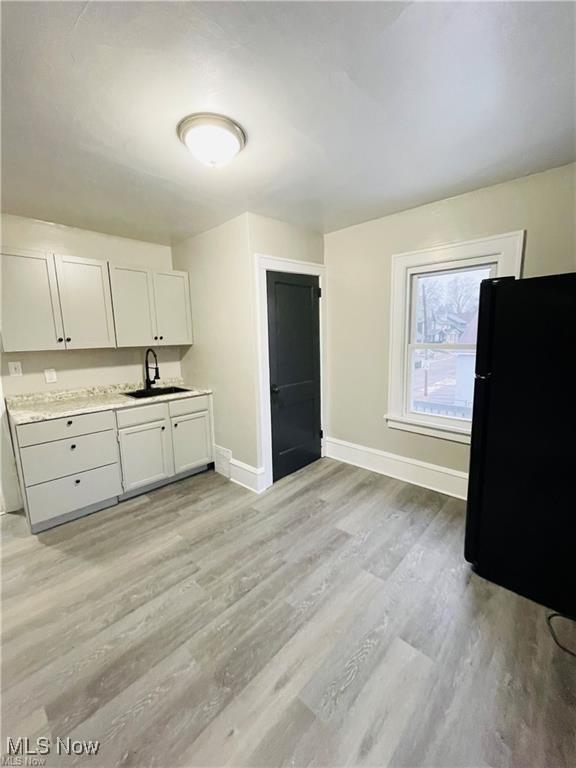 2511 4th St NW, Canton, OH 44708 - kitchen with a sink, baseboards, freestanding refrigerator, light wood finished floors, and light countertops