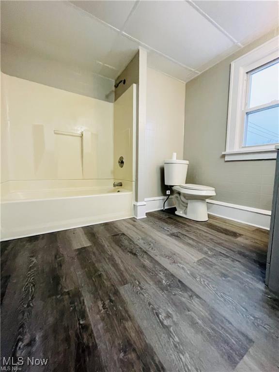 2511 4th St NW, Canton, OH 44708 - bathroom featuring toilet, wood finished floors, tub / shower combination, and baseboards