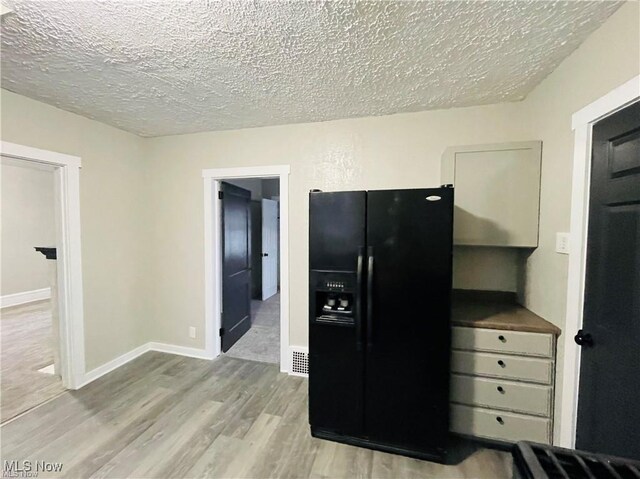 2511 4th St NW, Canton, OH 44708 - kitchen featuring black fridge, a textured ceiling, wood finished floors, and baseboards