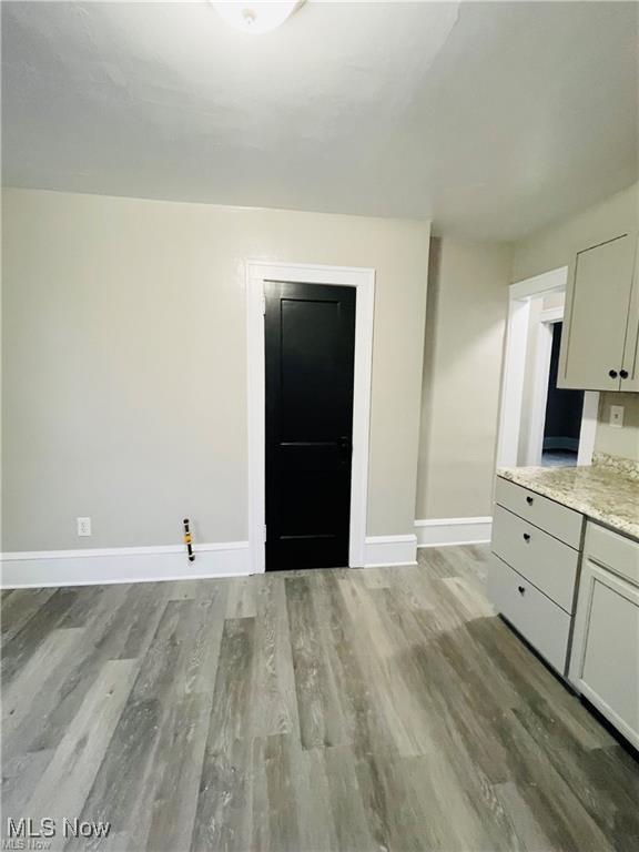 2511 4th St NW, Canton, OH 44708 - unfurnished dining area with baseboards and light wood-style flooring