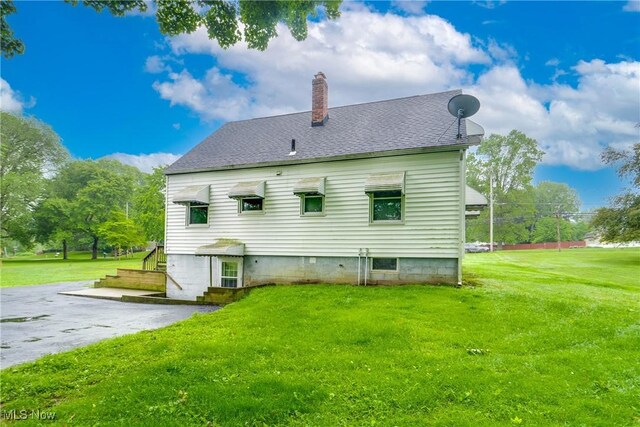 3985 Etter Rd, Mogadore, OH 44260 - rear view of property featuring a chimney, a lawn, and roof with shingles