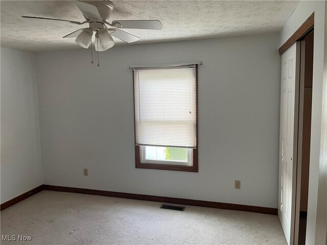 1023 55th St NE, Canton, OH 44721 - spare room with light carpet, baseboards, a textured ceiling, and ceiling fan