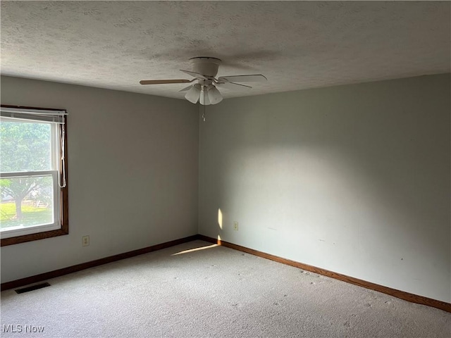 1023 55th St NE, Canton, OH 44721 - unfurnished room with carpet floors, a ceiling fan, baseboards, and a textured ceiling