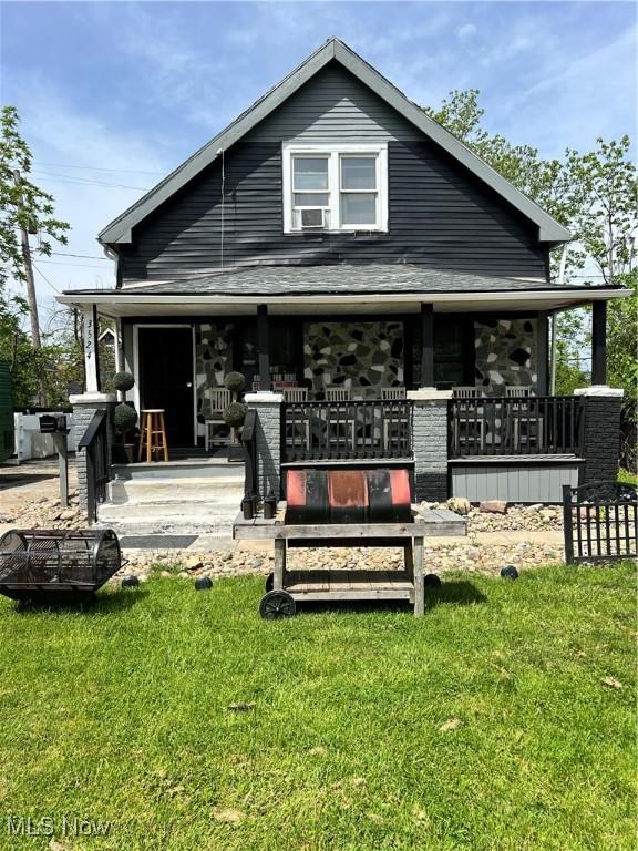 3524 E 139th St, Cleveland, OH 44120 - back of property with covered porch, a yard, and stone siding