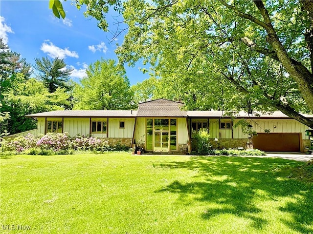 15959 Ridge Rd, North Royalton, OH 44133 - view of front facade featuring a garage, a front lawn, board and batten siding, stone siding, and roof with shingles