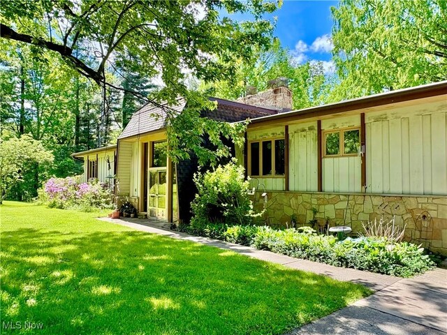 15959 Ridge Rd, North Royalton, OH 44133 - view of front of property featuring a front yard, stone siding, a chimney, and board and batten siding