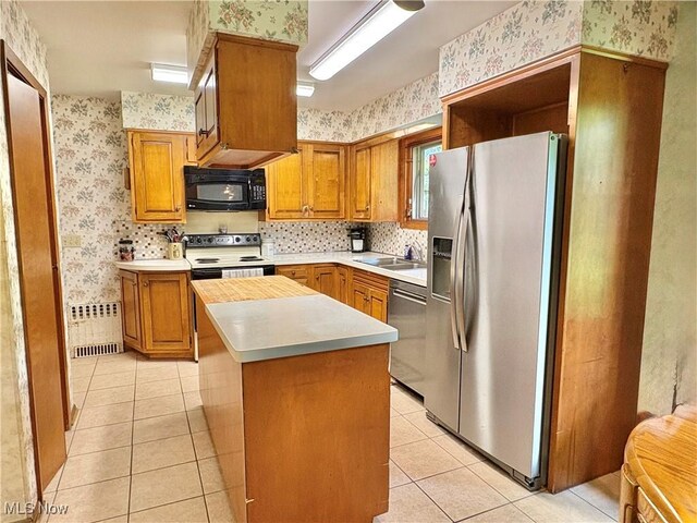 15959 Ridge Rd, North Royalton, OH 44133 - kitchen featuring wallpapered walls, stainless steel appliances, radiator heating unit, a sink, and light tile patterned flooring