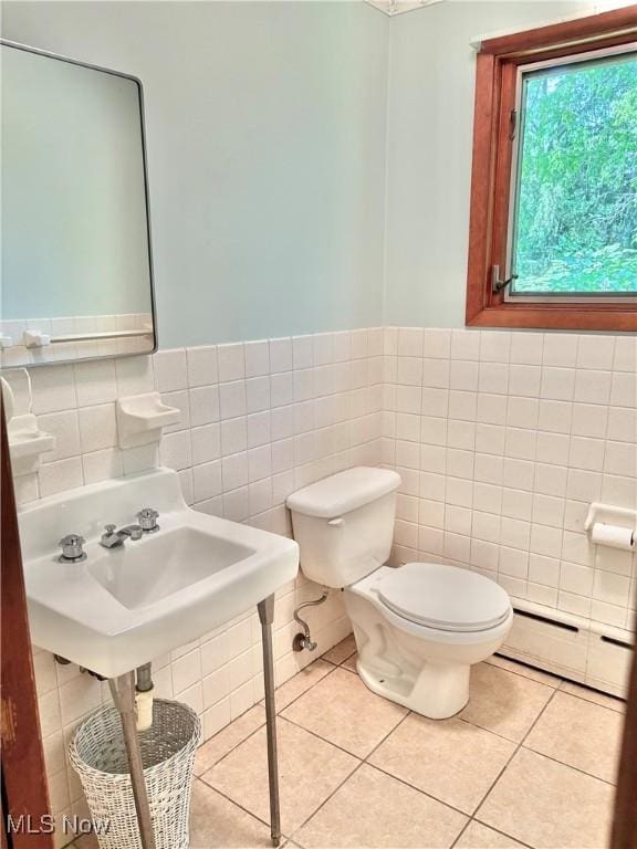 15959 Ridge Rd, North Royalton, OH 44133 - bathroom with tile walls, baseboard heating, toilet, tile patterned floors, and a wainscoted wall