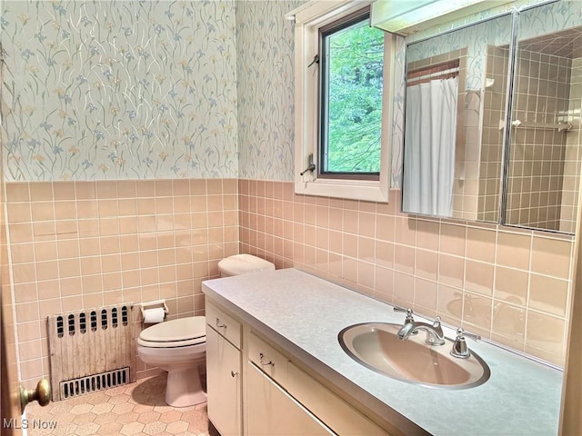 15959 Ridge Rd, North Royalton, OH 44133 - bathroom with radiator, wallpapered walls, tile walls, vanity, and toilet