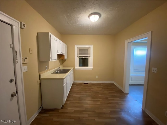 3454 E 118th St, Cleveland, OH 44120 - kitchen with a textured ceiling, a sink, light countertops, white cabinets, and dark wood-style flooring