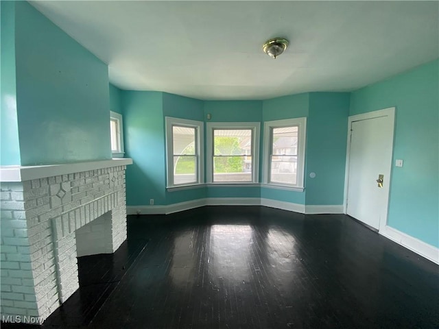 3454 E 118th St, Cleveland, OH 44120 - unfurnished living room with dark wood-style floors, baseboards, and a fireplace