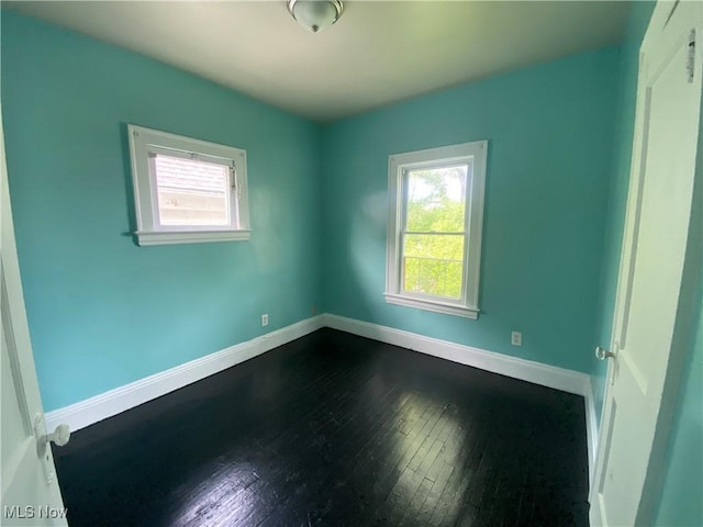 3454 E 118th St, Cleveland, OH 44120 - empty room featuring plenty of natural light, dark wood-type flooring, and baseboards