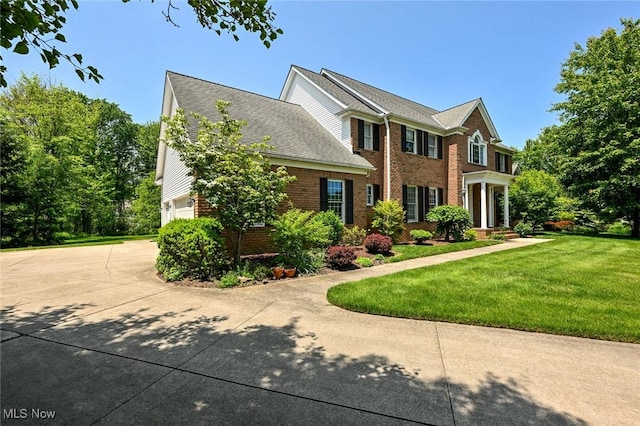 304 Fox Way, Chagrin Falls, OH 44022 - view of front of home with brick siding, a front yard, concrete driveway, and a garage