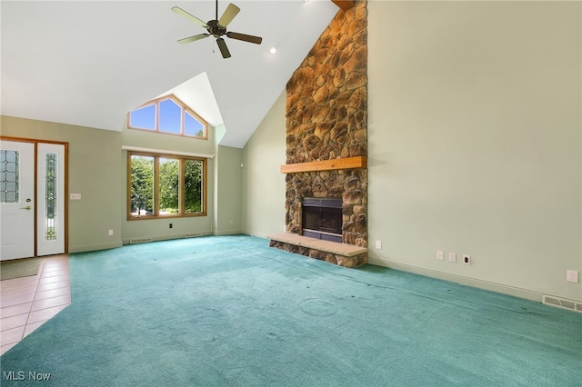 1908 Players Cir, Uniontown, OH 44685 - unfurnished living room with high vaulted ceiling, ceiling fan, a stone fireplace, carpet, and tile patterned flooring