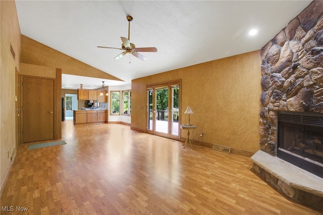 1908 Players Cir, Uniontown, OH 44685 - unfurnished living room featuring light wood-type flooring, a ceiling fan, a fireplace, baseboards, and high vaulted ceiling